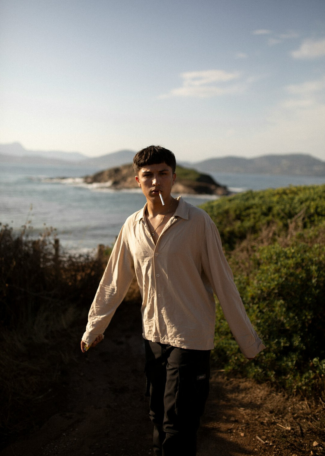 Portrait of a young man with short dark hair and a light shirt