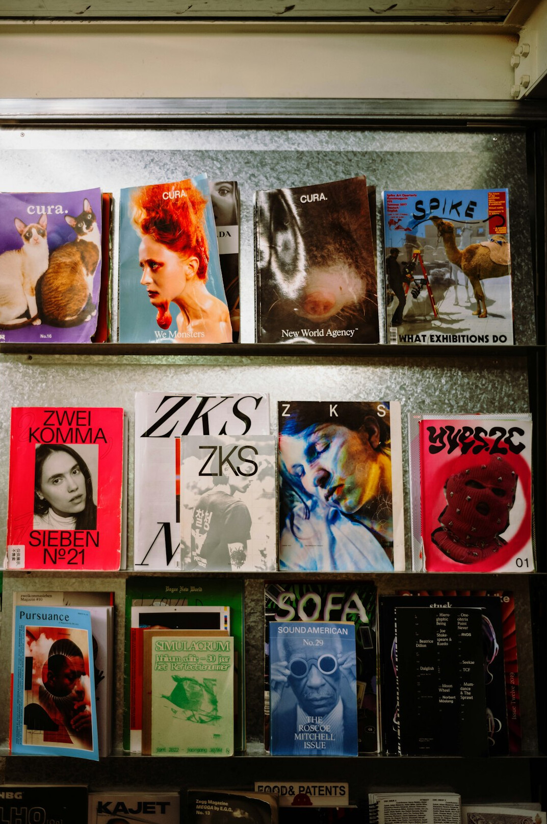 Vintage entertainment magazines and printed photographs spread on a wooden desk